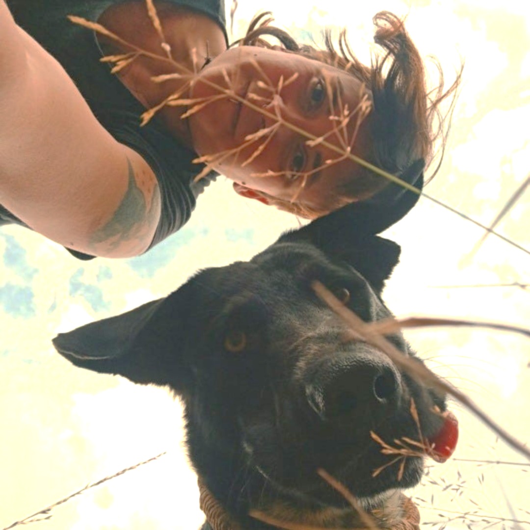 Picture of a woman and a dog looking into the camera